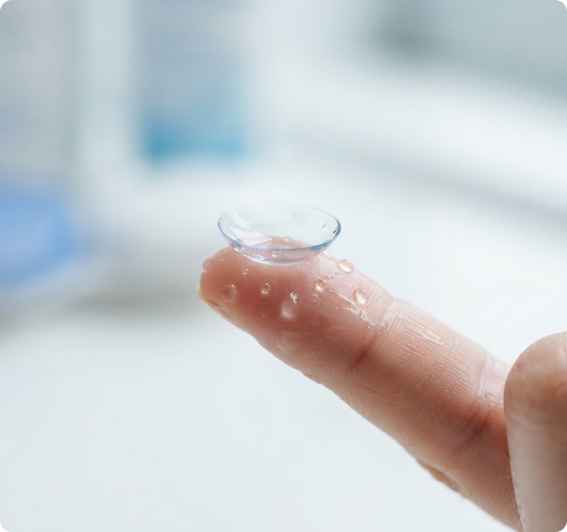 A soft contact lens balanced on a fingertip